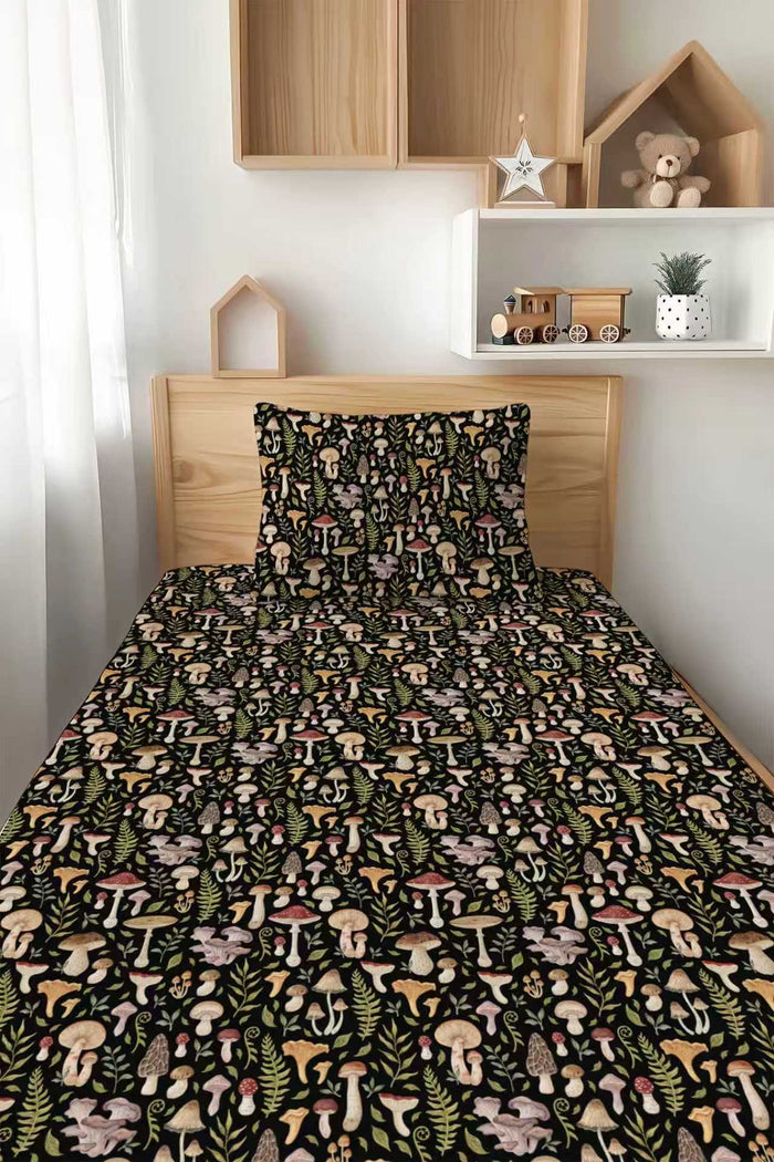 A neatly made bed features the Jammie Session Mystic Mushrooms Twin Fitted Sheet and Pillowcase Set, with a vibrant mushroom and foliage pattern; wooden shelves, decor, and a toy train are in the background.