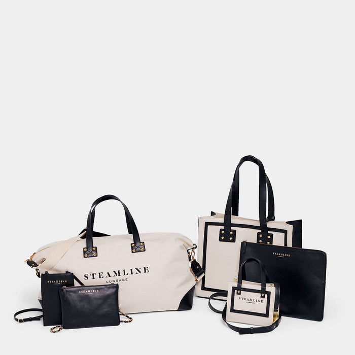 Designer travel set of The Navigator handbag in sustainable canvas and black leather with gold trims